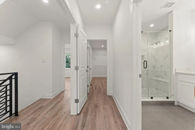 a view of a hallway with wooden floor and closet area