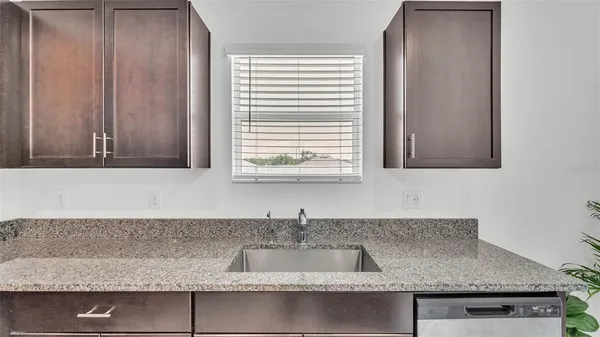a kitchen with granite countertop a sink and a granite counter tops with a window
