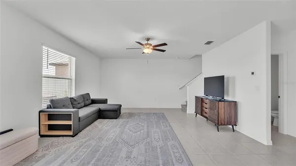 a living room with furniture and a ceiling fan