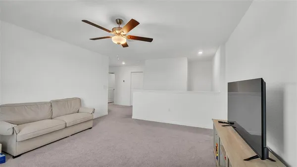 a living room with furniture and a ceiling fan