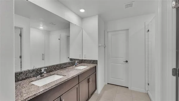 a bathroom with a granite countertop sink and a mirror