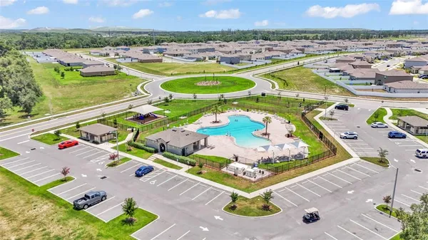 an aerial view of a swimming pool and outdoor seating