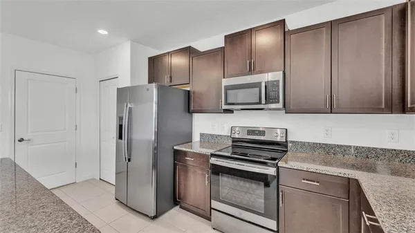 a kitchen with stainless steel appliances granite countertop a refrigerator and a stove top oven