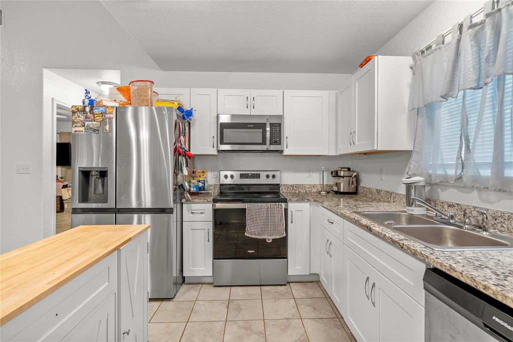 420 Whitney Court Rio Vista, TX 76093 - Photo 11 of 25 a kitchen with stainless steel appliances granite countertop a sink refrigerator and microwave