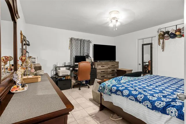 a bedroom with a bed and a flat tv screen on the dresser