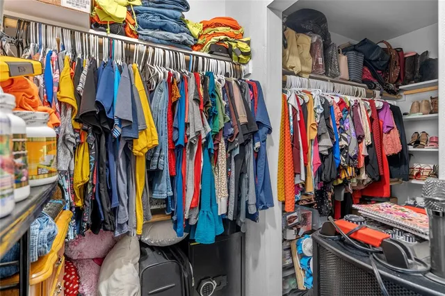 a view of walk in closet with clothes