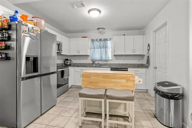 a kitchen with granite countertop stainless steel appliances and white cabinets