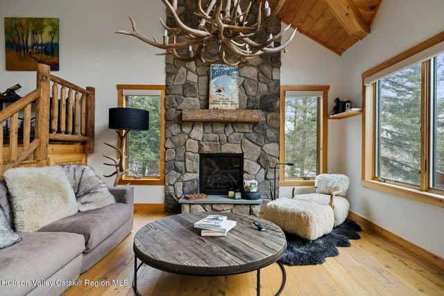 a living room with furniture a flat screen tv and a floor to ceiling window