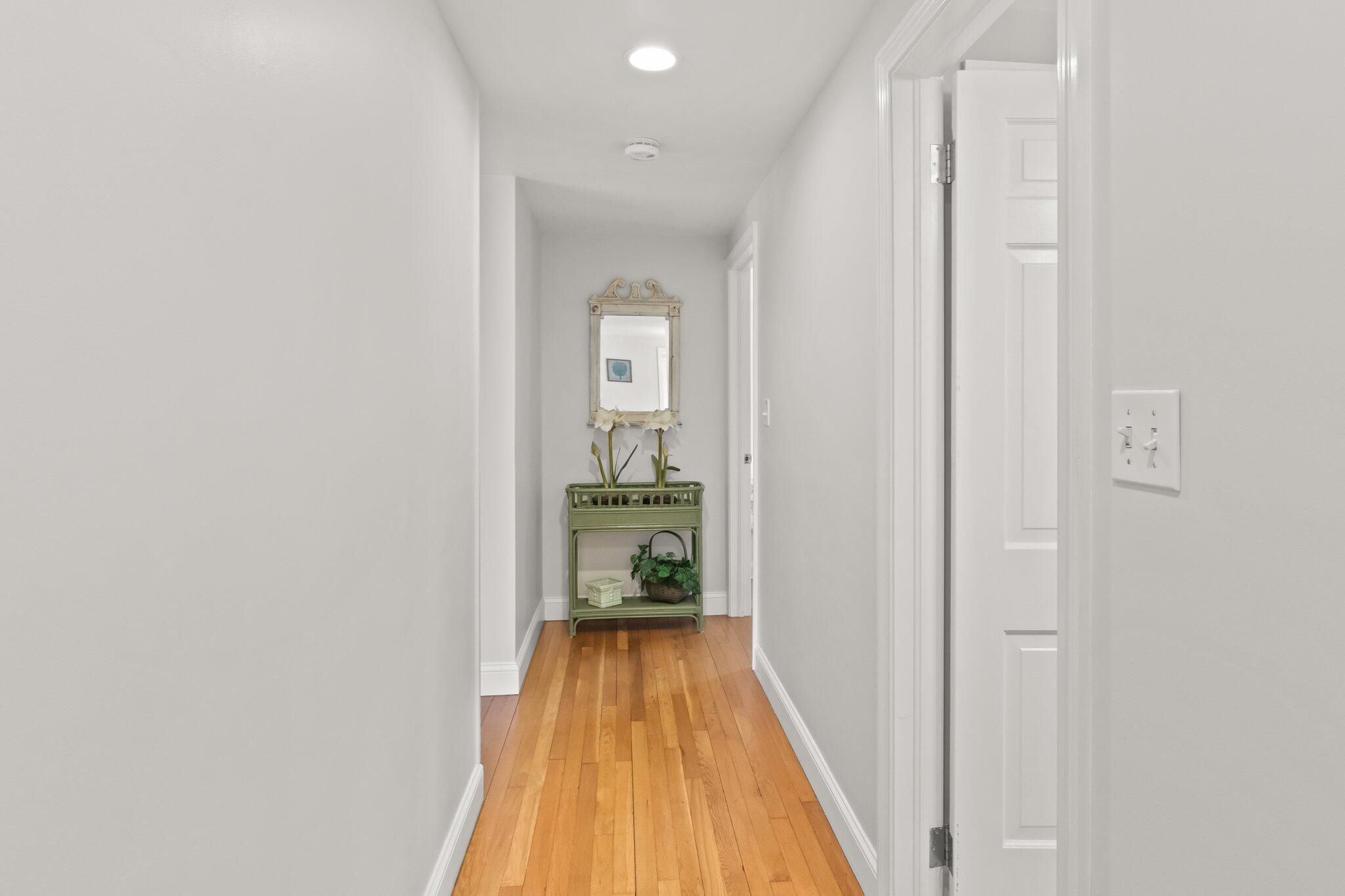29 Jesse Eldredge Road Harwich, MA 02645 - Photo 20 of 56 a view of a hallway with wooden floor and a bathroom