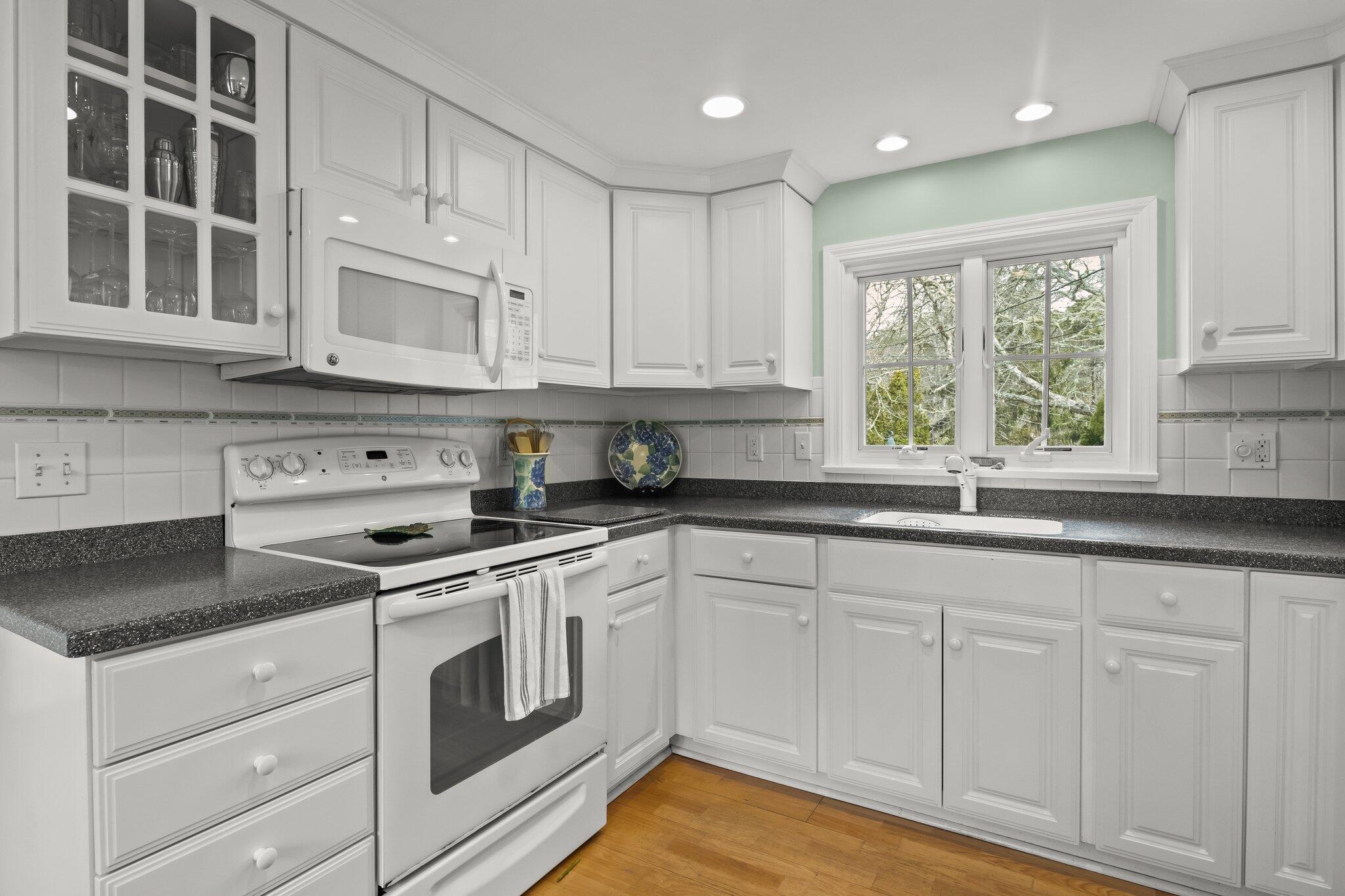 29 Jesse Eldredge Road Harwich, MA 02645 - Photo 27 of 56 a kitchen with granite countertop white cabinets and white appliances