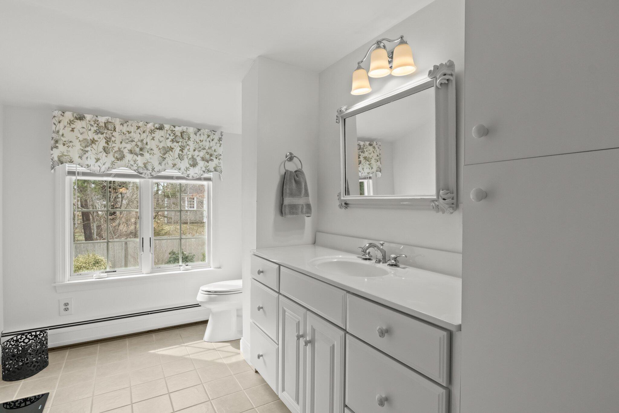 29 Jesse Eldredge Road Harwich, MA 02645 - Photo 36 of 56 a bathroom with a double vanity sink toilet and a mirror