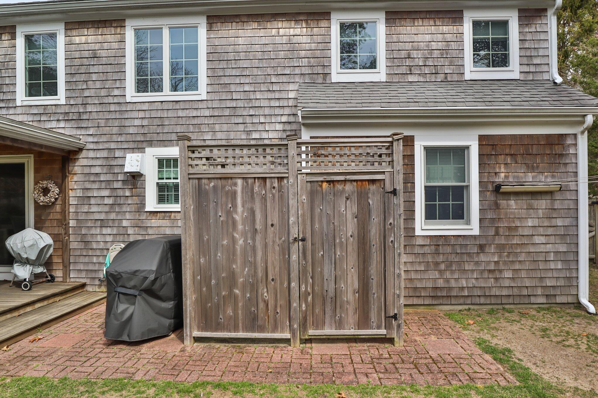 29 Jesse Eldredge Road Harwich, MA 02645 - Photo 46 of 56 a view of a brick house with many windows and potted plants