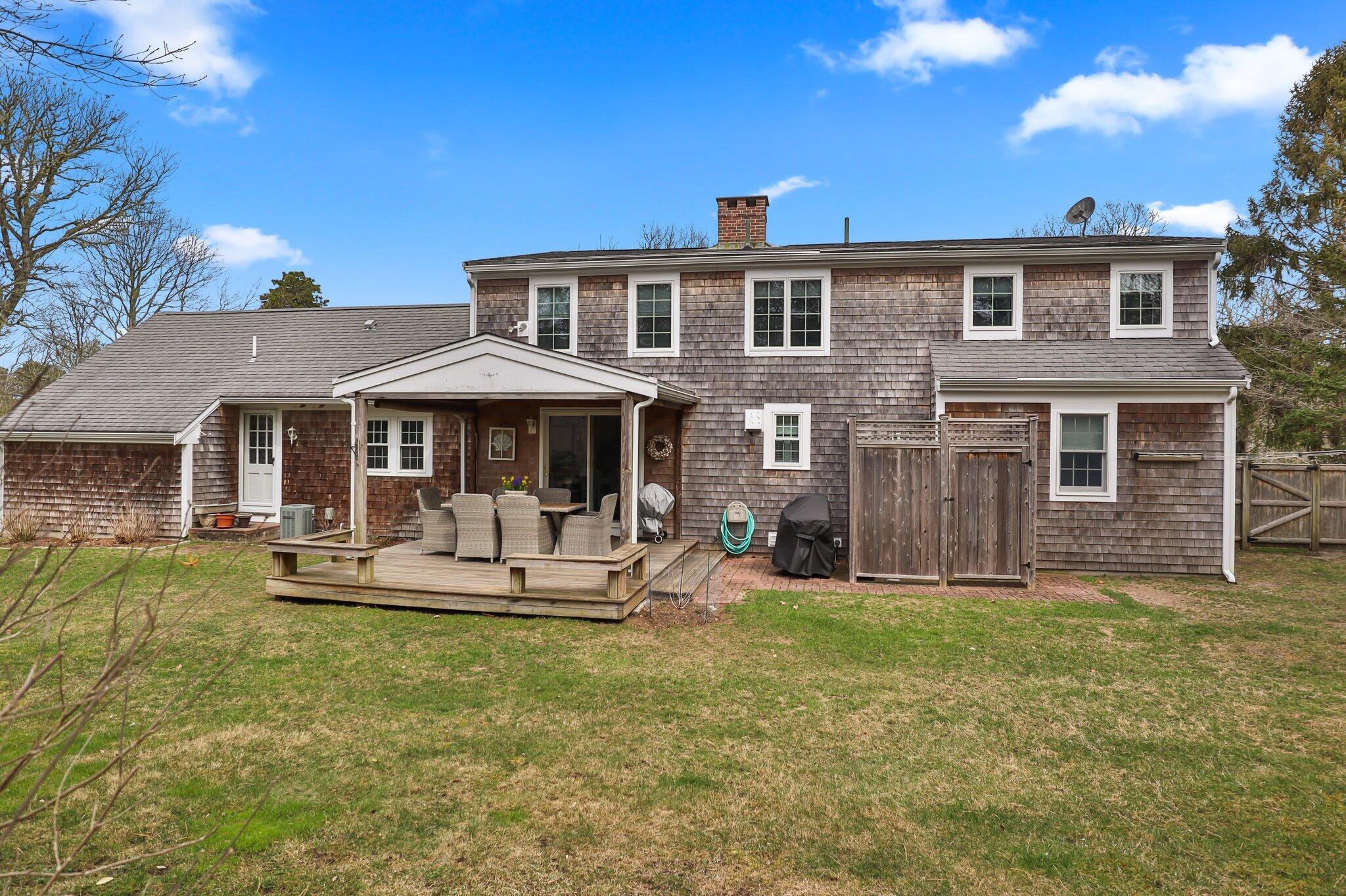 29 Jesse Eldredge Road Harwich, MA 02645 - Photo 48 of 56 a front view of a house with a yard table and chairs