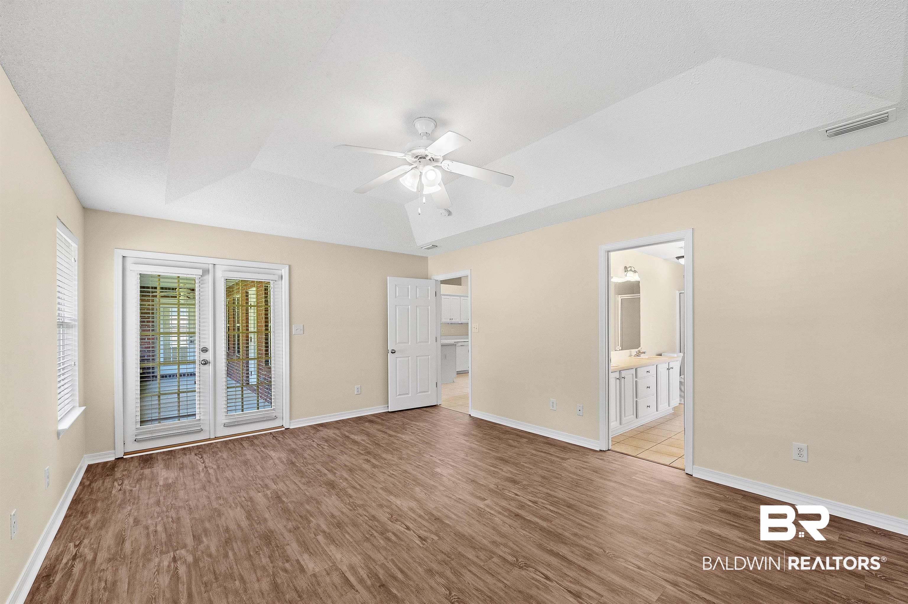 12443 Venice Boulevard Foley, AL 36535 - Photo 43 of 59 Spare room featuring a raised ceiling, ceiling fan, wood-type flooring, and french doors