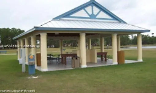 a view of a house with floor to ceiling windows and a lawn chair