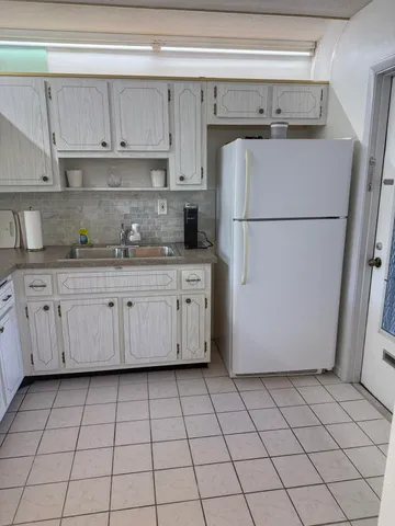 a kitchen with granite countertop white cabinets stainless steel appliances and a sink