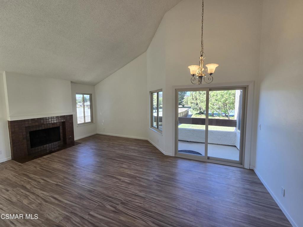 1778 Sinaloa Road, Unit 294 Simi Valley, CA 93065 - Photo 1 of 13 an empty room with wooden floor fireplace and windows