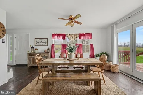 a view of a dining room with furniture a chandelier and wooden floor