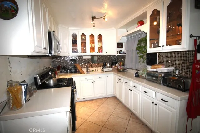 a kitchen with white cabinets a sink and a stove