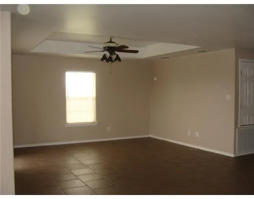 an empty room with a window and a ceiling fan