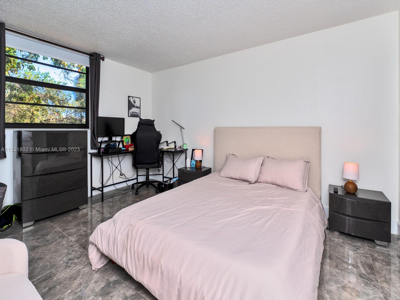10865 Southwest 112th Avenue, Unit 209 Miami, FL 33176 - Photo 17 of 29 a bedroom with a bed and a dresser next to a window