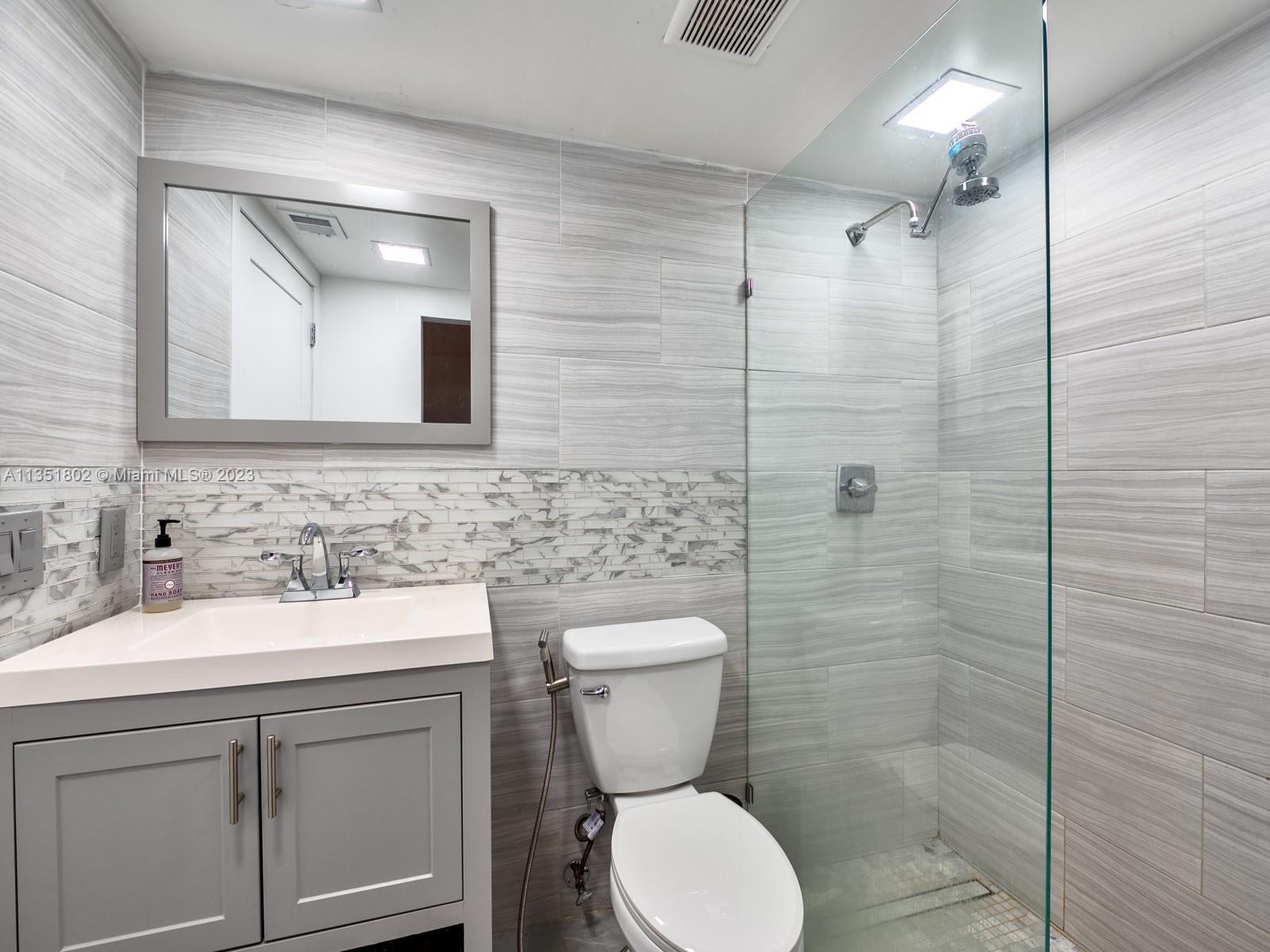 10865 Southwest 112th Avenue, Unit 209 Miami, FL 33176 - Photo 18 of 29 a bathroom with a toilet sink and mirror