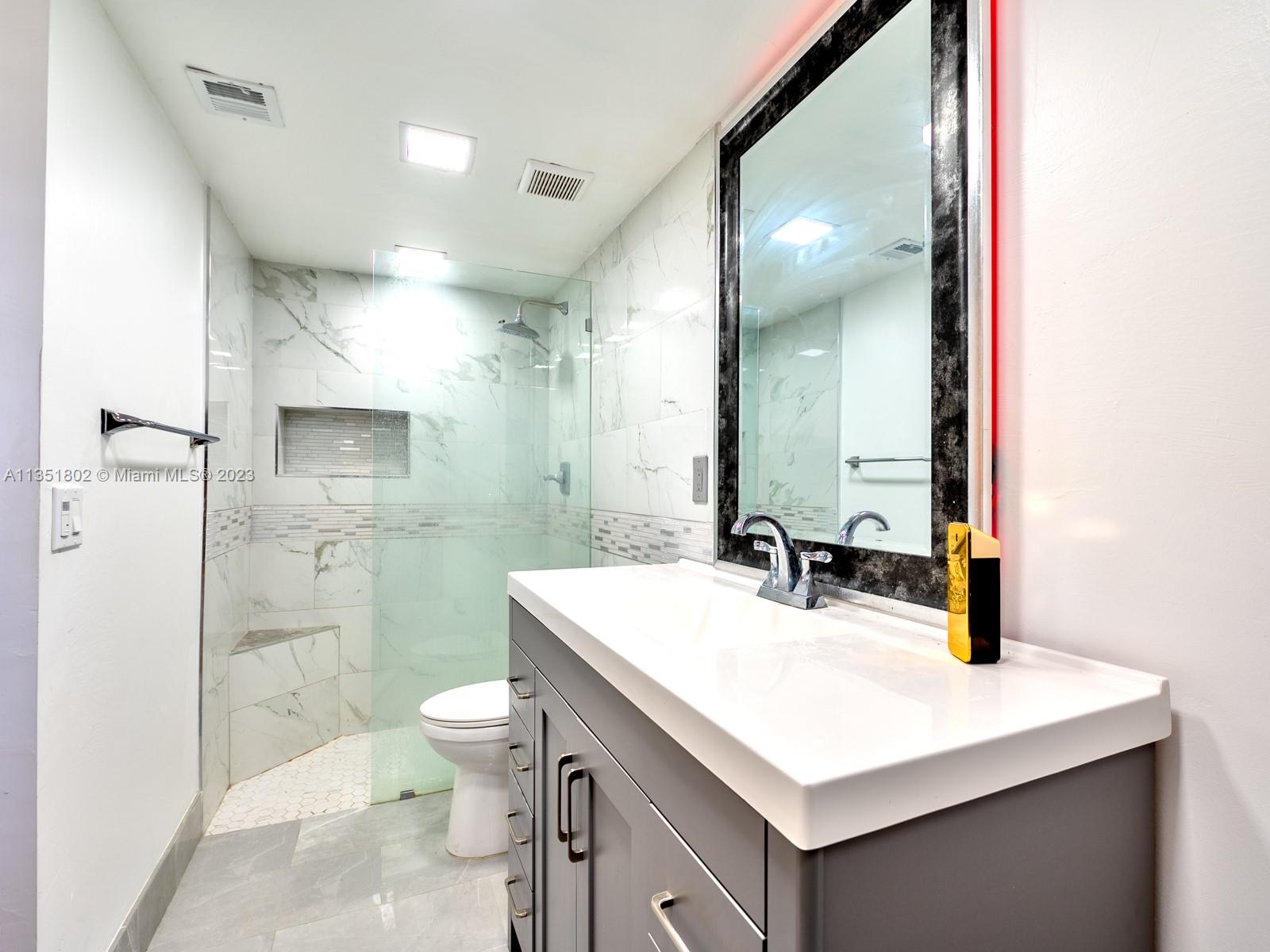 10865 Southwest 112th Avenue, Unit 209 Miami, FL 33176 - Photo 23 of 29 a bathroom with a sink a toilet a mirror and shower