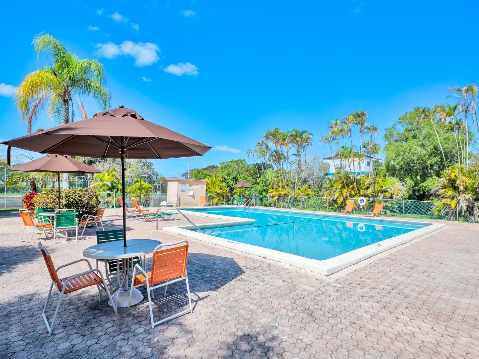 10865 Southwest 112th Avenue, Unit 209 Miami, FL 33176 - Photo 27 of 29 a view of a swimming pool with chairs in patio