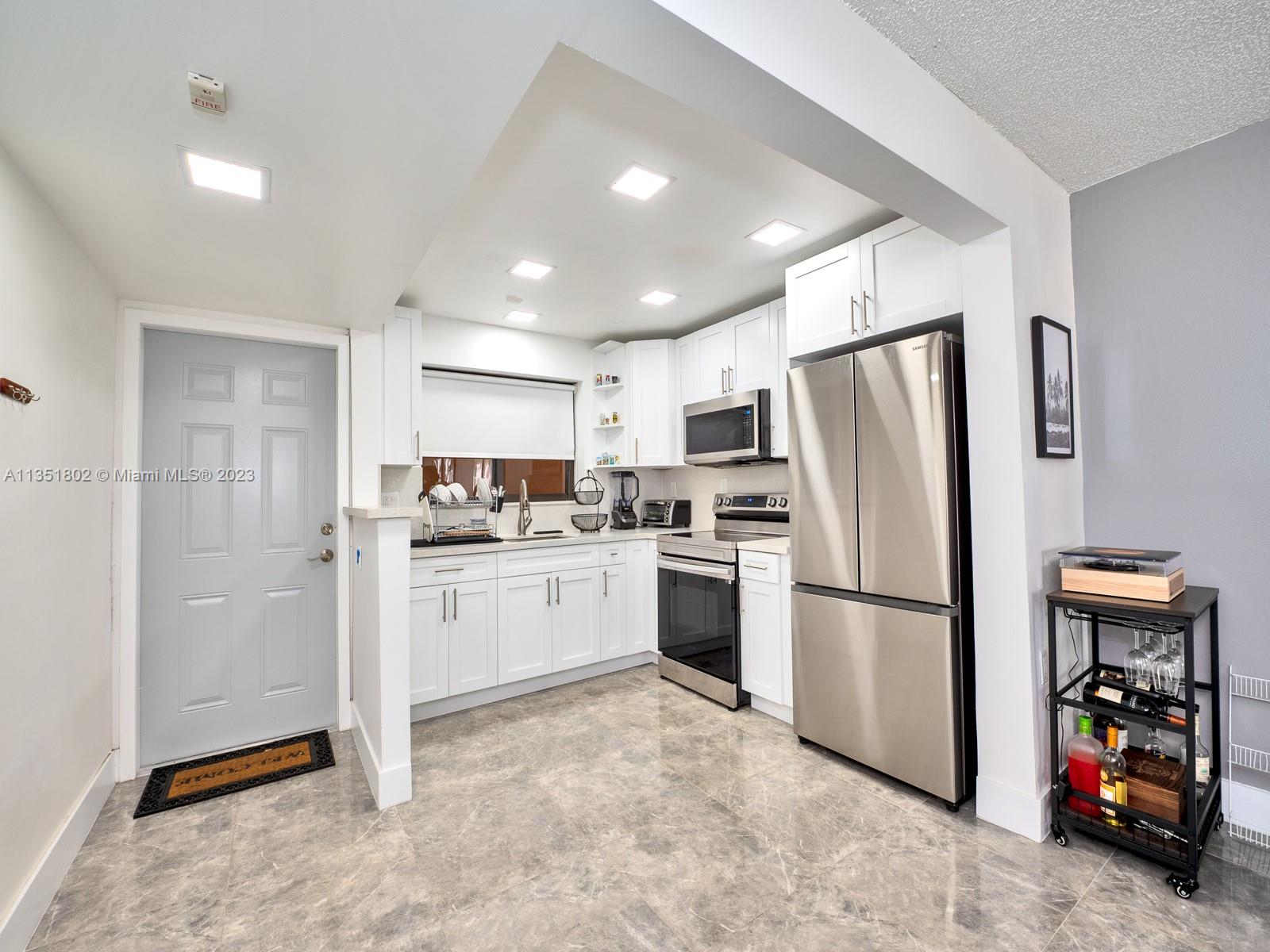 10865 Southwest 112th Avenue, Unit 209 Miami, FL 33176 - Photo 4 of 29 a kitchen with refrigerator a sink and a stove
