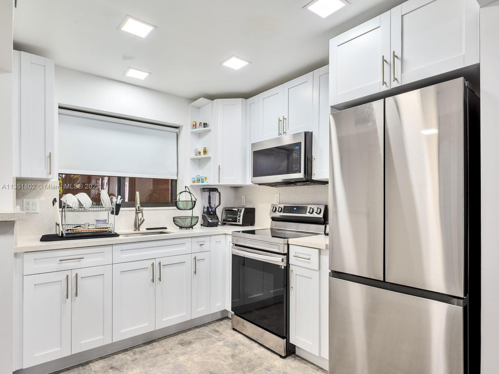 10865 Southwest 112th Avenue, Unit 209 Miami, FL 33176 - Photo 5 of 29 a kitchen with a sink appliances and cabinets
