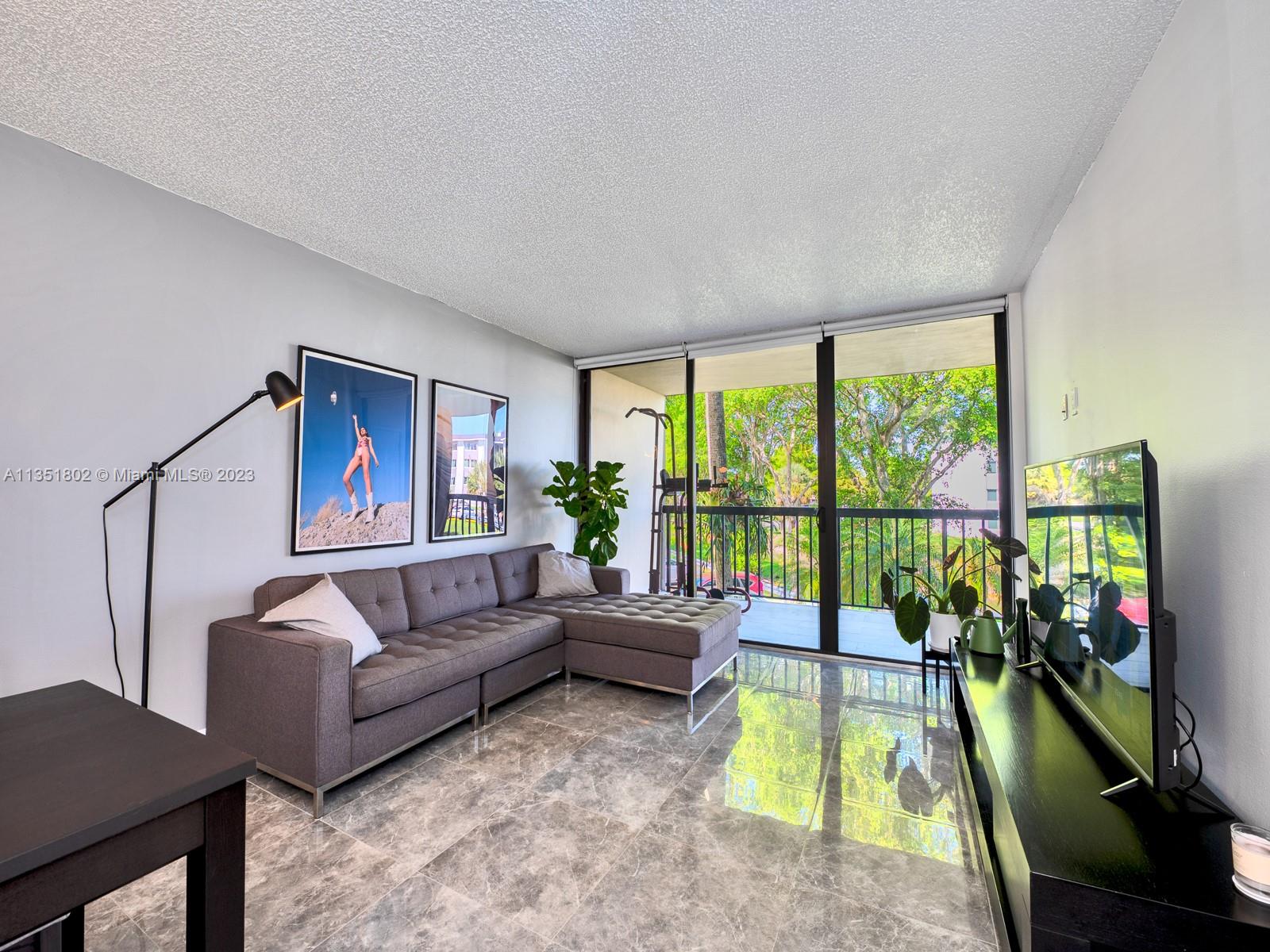 10865 Southwest 112th Avenue, Unit 209 Miami, FL 33176 - Photo 6 of 29 a living room with furniture and a large window