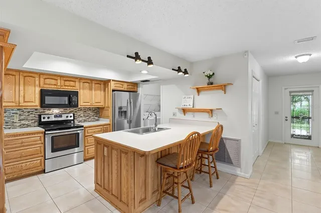 a kitchen with stainless steel appliances kitchen island granite countertop a sink and cabinets