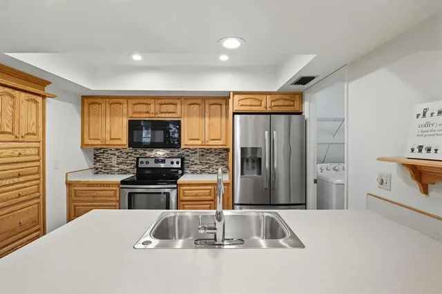 a kitchen with stainless steel appliances granite countertop a refrigerator stove and sink