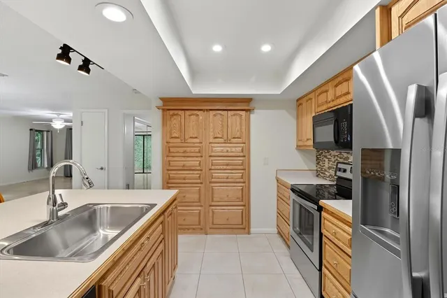 a kitchen with stainless steel appliances granite countertop a sink stove and refrigerator