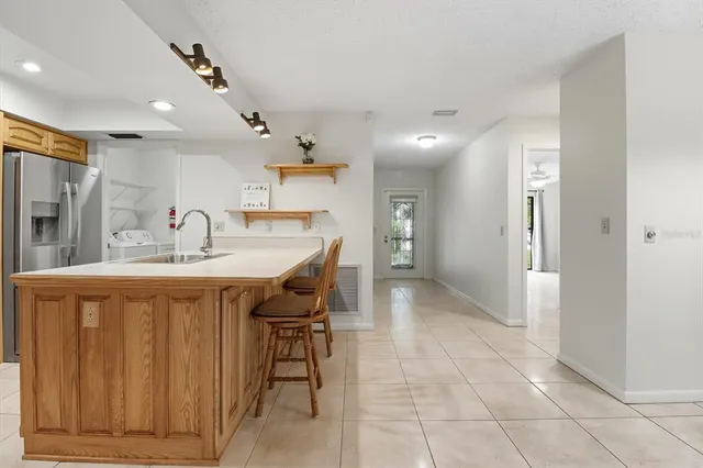 a dining hall with stainless steel appliances a sink and cabinets