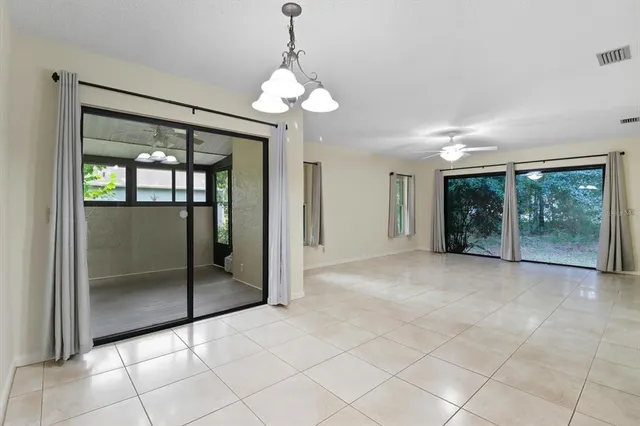 a view of an empty room with sliding glass door and chandelier