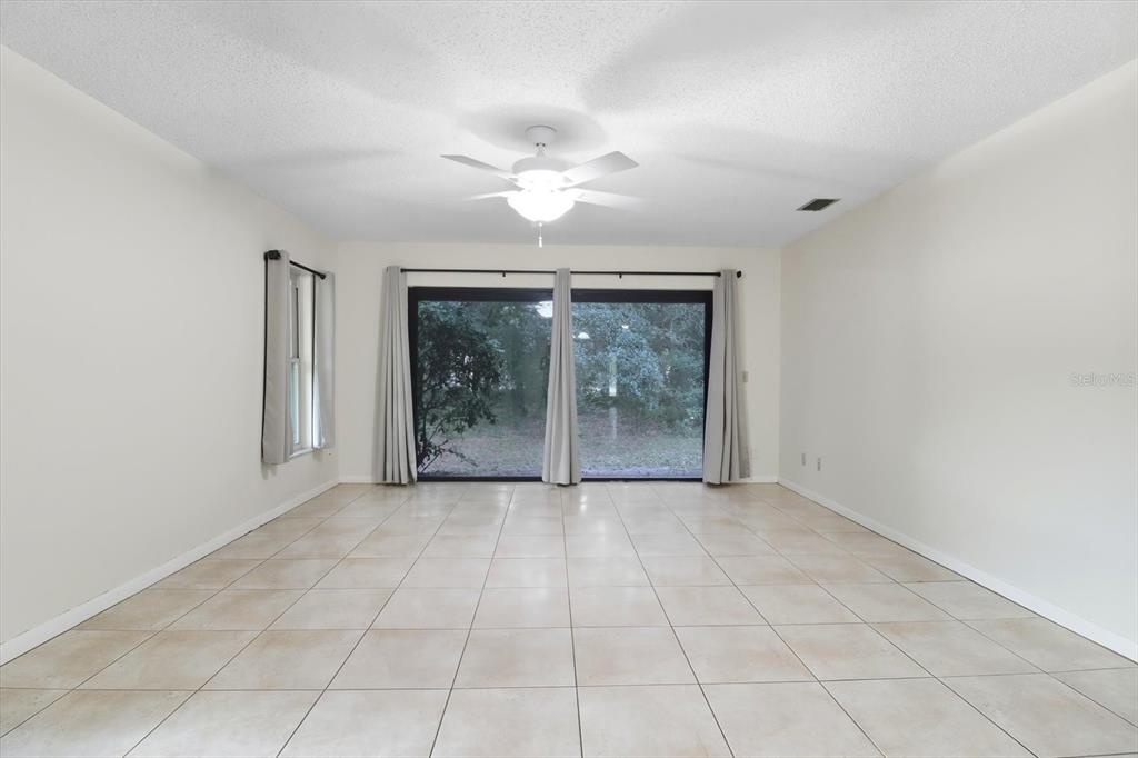 25 Jamaica Street Homosassa, FL 34446 - Photo 21 of 49 an empty room with floor to ceiling windows and a ceiling fan