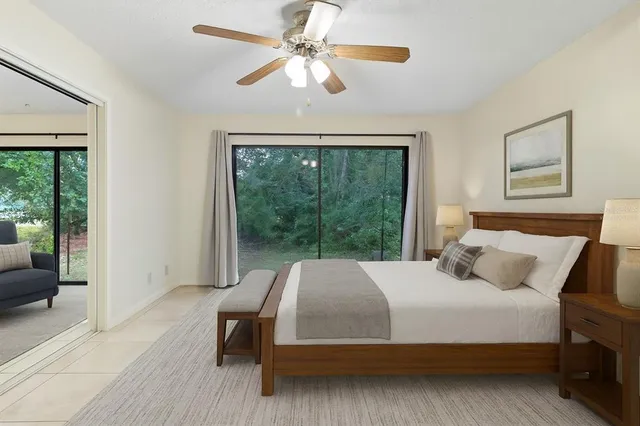 a bedroom with a bed a couch and a large window