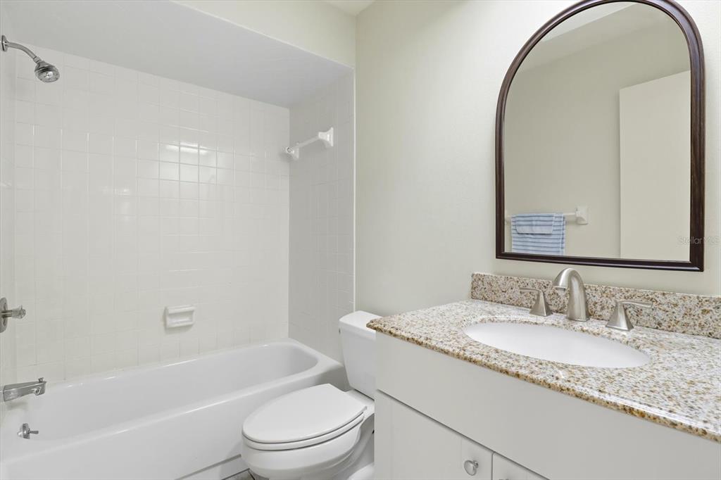 25 Jamaica Street Homosassa, FL 34446 - Photo 34 of 49 a bathroom with a granite countertop sink a toilet and a mirror