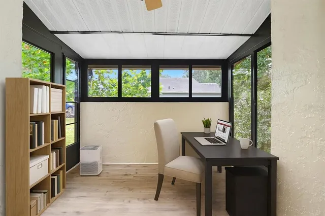 a view of a workspace with furniture and a window