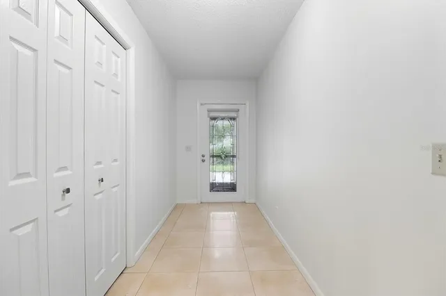 a view of a hallway with white walls and a window