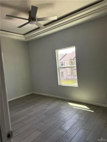 a view of empty room with window and wooden floor