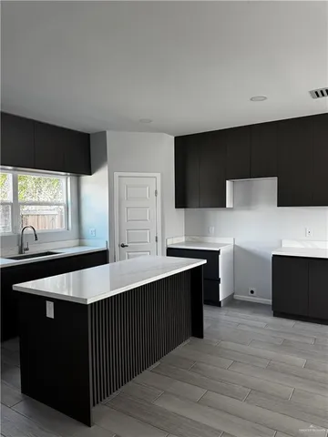 a kitchen with a sink window and cabinets