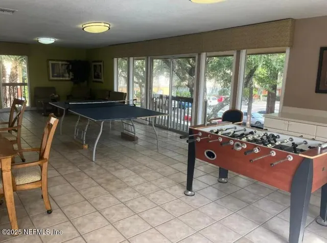 a living room with furniture a rug and a floor to ceiling window