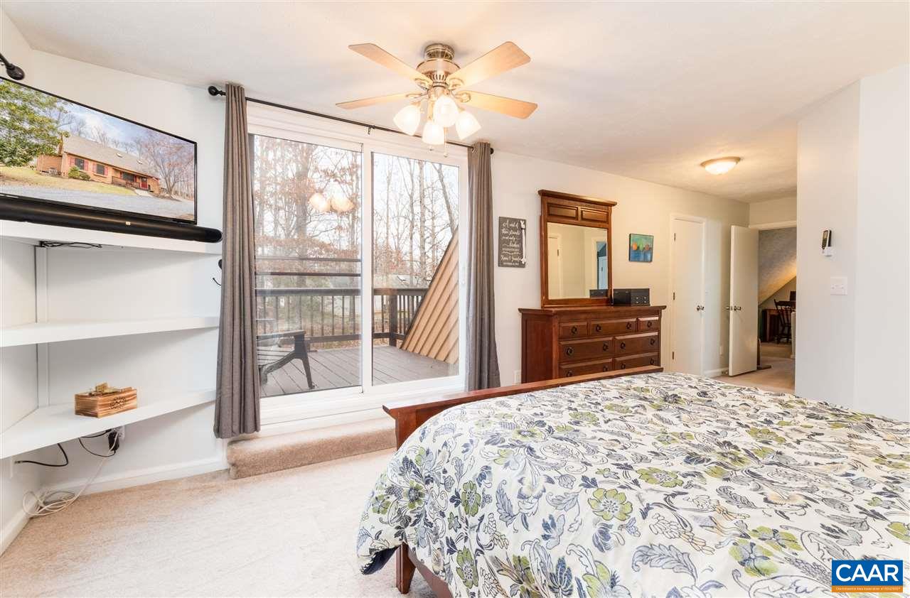 33 Oak Grove Road Palmyra, VA 22963 - Photo 29 of 42 a bedroom with a large bed and a chandelier