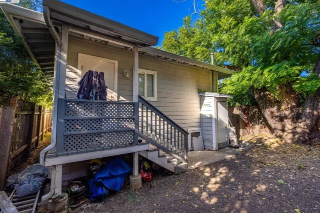 a view of a house with a small yard and wooden fence