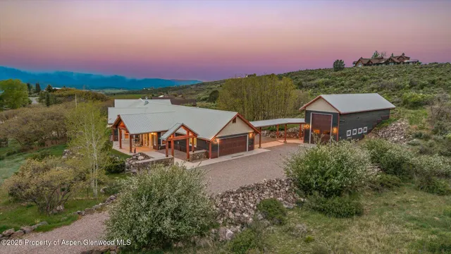 an aerial view of a house with a garden and lake view