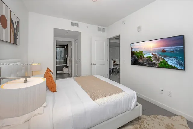 a bedroom with a bed and a flat screen tv