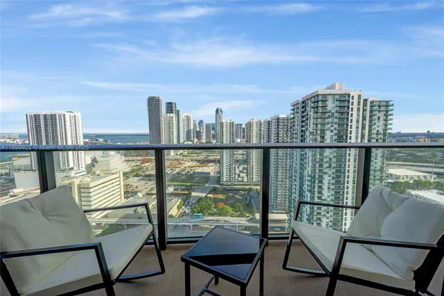 a view of a city from a balcony with furniture