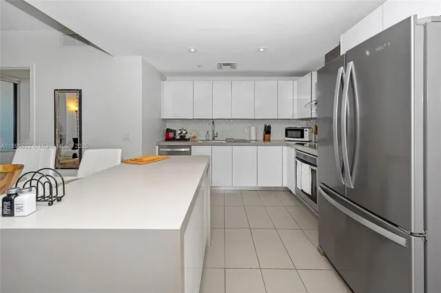a kitchen with granite countertop a refrigerator and a sink